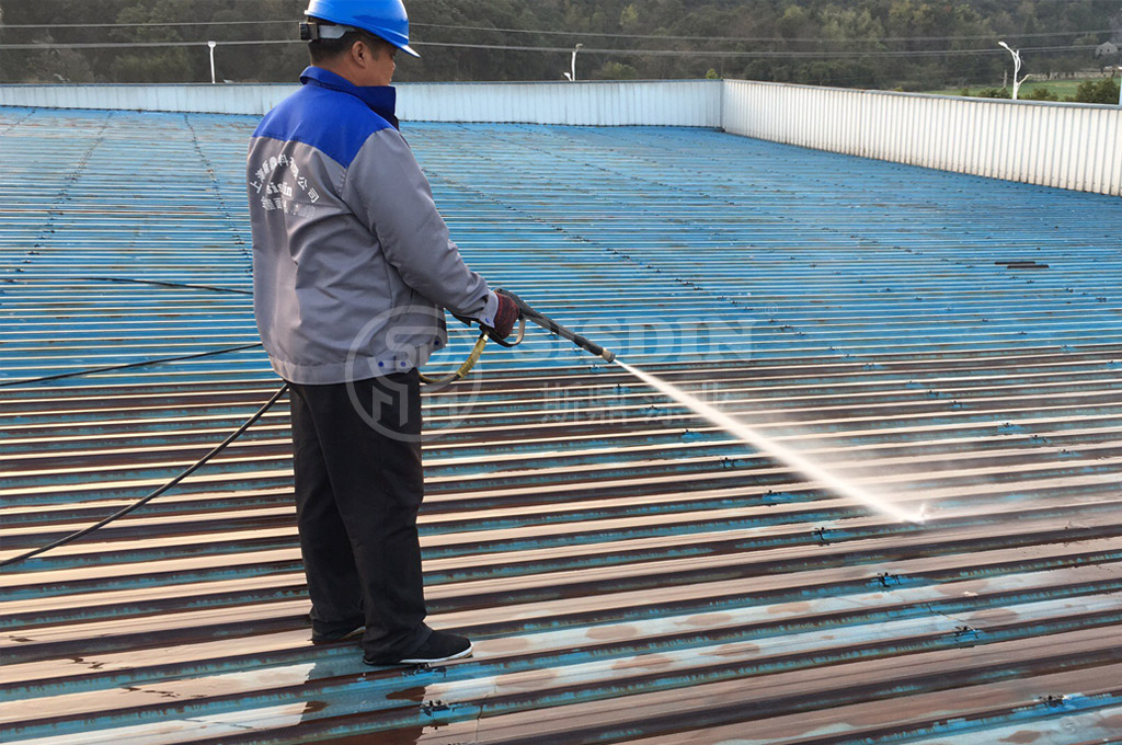 斯鼎厂房金属屋面彩钢瓦翻新防腐施工团队正在清洗一企业金属屋面